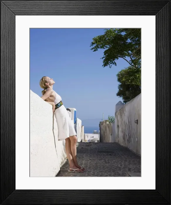 Framed Print : Woman leaning on wall outdoors smiling Framed Print : Woman leaning on wall outdoors smiling