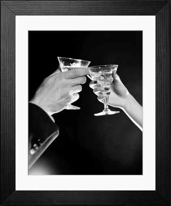 Framed Print : Man's hand and woman's hand toasting with Martini Framed Print : Man's hand and woman's hand toasting with Martini