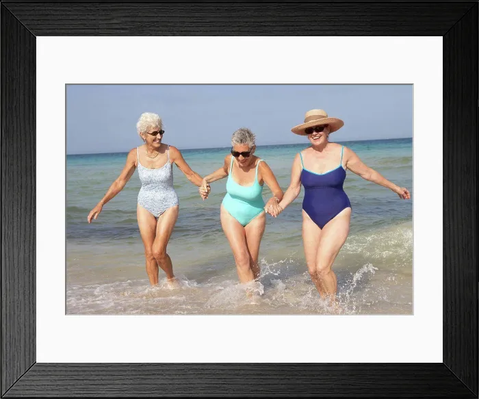 Framed Print : Senior women walking in waves on beach Framed Print : Senior women walking in waves on beach