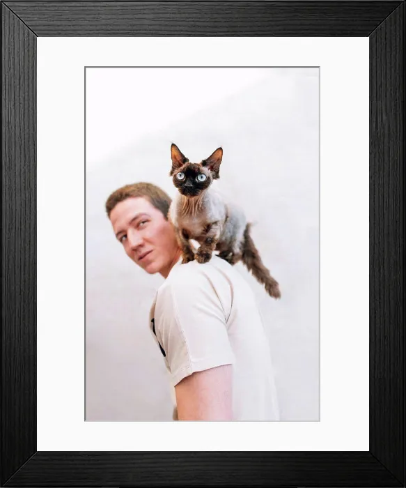 Framed Print : Man looking at cat on shoulder by wall