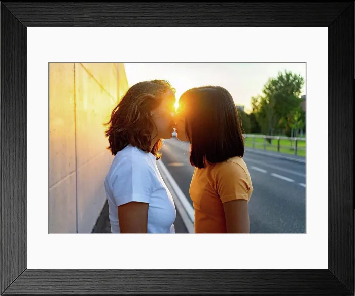 Framed Print : Young lesbian couple kissing during sunset Framed Print : Young lesbian couple kissing during sunset
