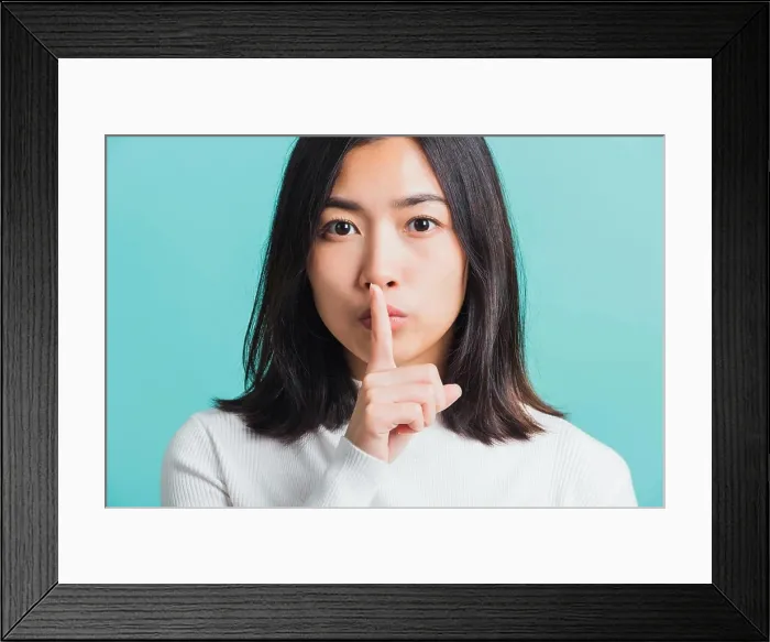 Framed Print : woman holding index finger on her mouth lips Framed Print : woman holding index finger on her mouth lips