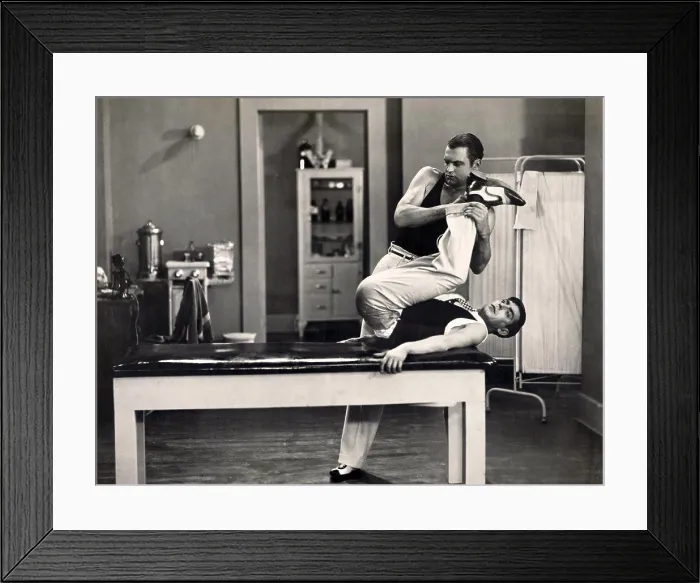 Framed Print : Male contortionist stretching legs of a patient Framed Print : Male contortionist stretching legs of a patient