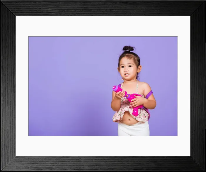Framed Print : Thai child funny hold toy water pistol and smile Framed Print : Thai child funny hold toy water pistol and smile