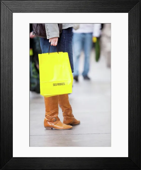 Framed Print : England, London, Oxford Street. A young lady on Oxford Street with bright yellow shopping bags from Selfridges Framed Print : England, London, Oxford Street. A young lady on Oxford Street with bright yellow shopping bags from Selfridges
