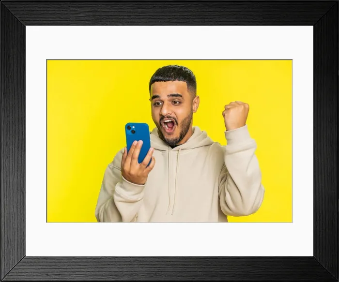 Framed Print : Happy excited winner man use smartphone celebrating success, winning play game, good lottery news Framed Print : Happy excited winner man use smartphone celebrating success, winning play game, good lottery news