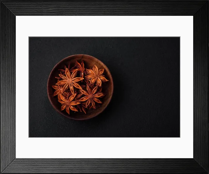 Framed Print : Star shaped spice star anise in a wooden round bowl Star shaped spice star anise in a wooden round bowl on a dark