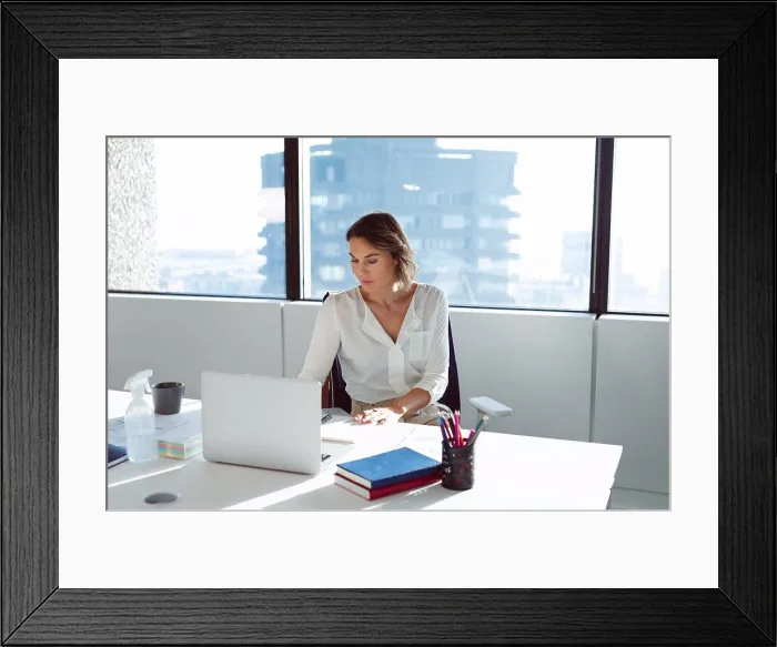 Framed Print : Caucasian businesswoman sitting at desk, using laptop at work. independent creative business at a modern office