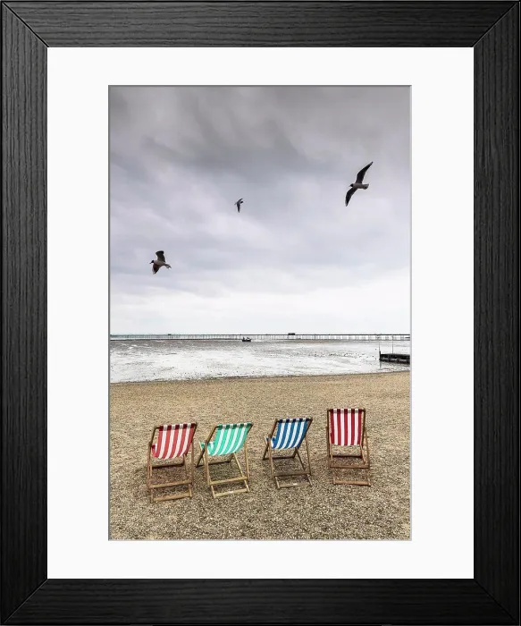 Framed Print : Seagulls fly over empty deckchairs on Jubilee Beach in Southend on a cloudy day Framed Print : Seagulls fly over empty deckchairs on Jubilee Beach in Southend on a cloudy day