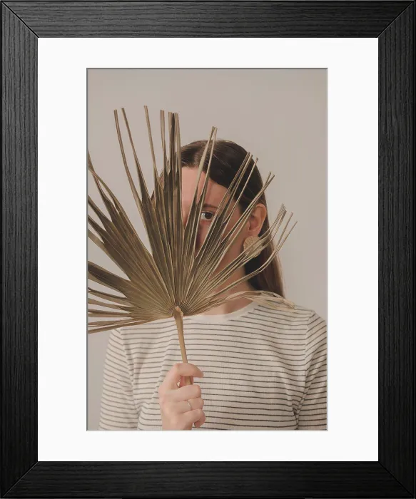 Framed Print : Portrait of a woman looking through a palm leaf. Young caucasian Framed Print : Portrait of a woman looking through a palm leaf. Young caucasian