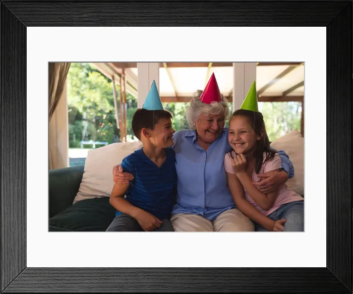 Framed Print : Senior caucasian woman spending time at home celebrating a birthday with her grandchildren