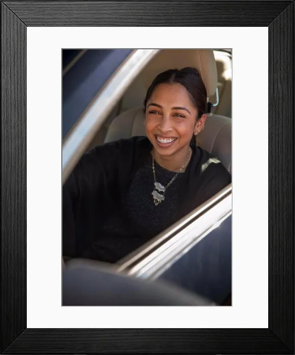 Framed Print : Portrait of woman sitting in drivers seat of car with window open, laughing and looking at camera Framed Print : Portrait of woman sitting in drivers seat of car with window open, laughing and looking at camera