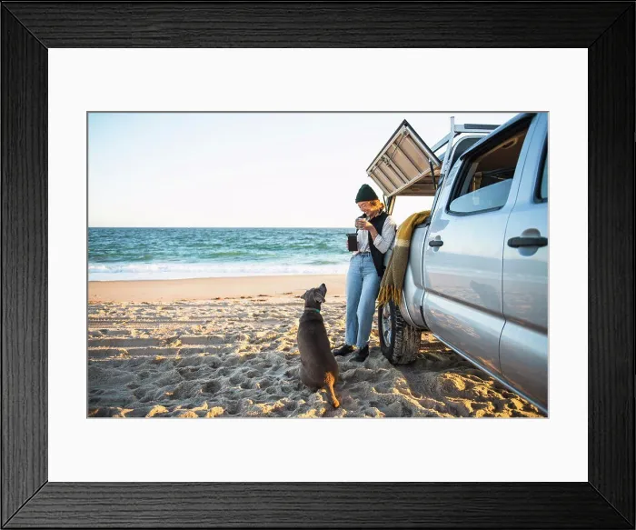 Framed Print : Young woman and her dog while beach car camping alone