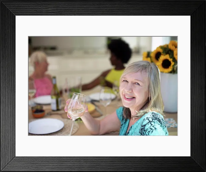 Framed Print : Portrait happy senior woman drinking white wine with friends at table