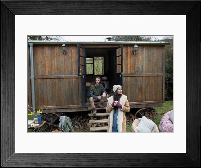 Framed Print : Couple enjoying coffee outside tiny cabin rental