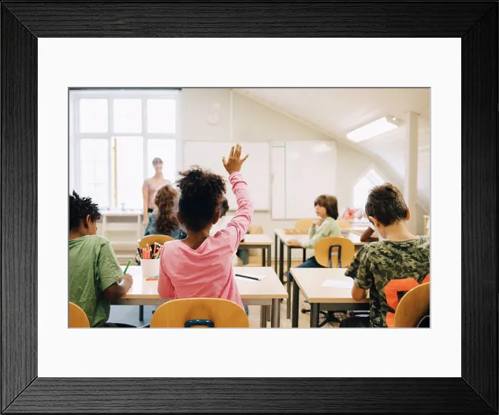 Framed Print : Rear view of boy raising hand while answering in class at elementary school Framed Print : Rear view of boy raising hand while answering in class at elementary school