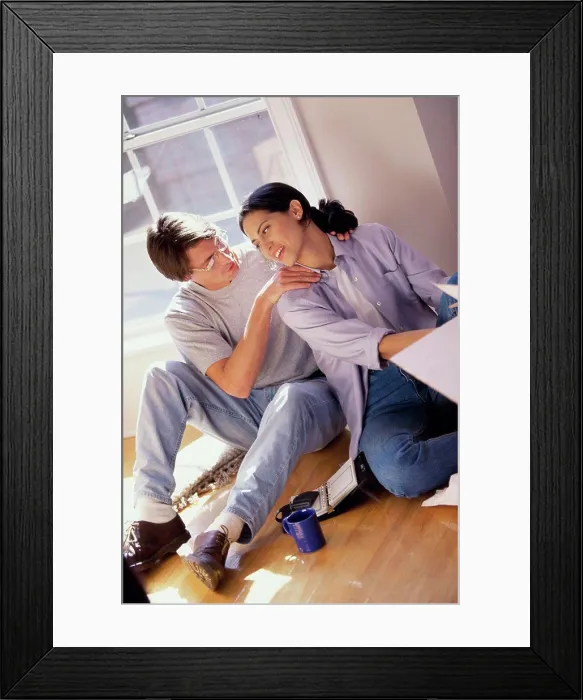 Framed Print : High angle view of a young couple sitting on the floor Framed Print : High angle view of a young couple sitting on the floor