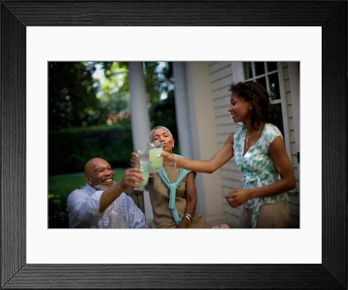 Framed Print : Mature couple sharing a toast with their daughter
