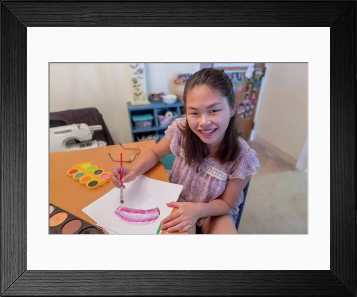Framed Print : Teen girl with a Learning Disability using paints Framed Print : Teen girl with a Learning Disability using paints