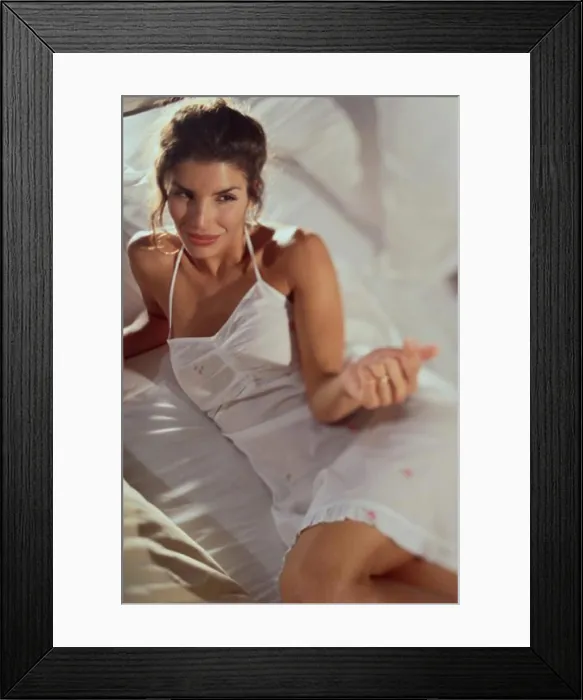 Framed Print : High angle view of a young woman lying on a bed Framed Print : High angle view of a young woman lying on a bed