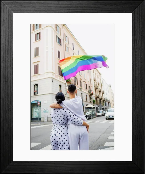 Framed Print : Rear view of young lesbian couple standing on a street, waving rainbow flag Framed Print : Rear view of young lesbian couple standing on a street, waving rainbow flag