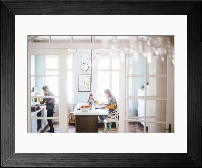 Framed Print : Woman using laptop while sitting with girl studying at kitchen island Framed Print : Woman using laptop while sitting with girl studying at kitchen island