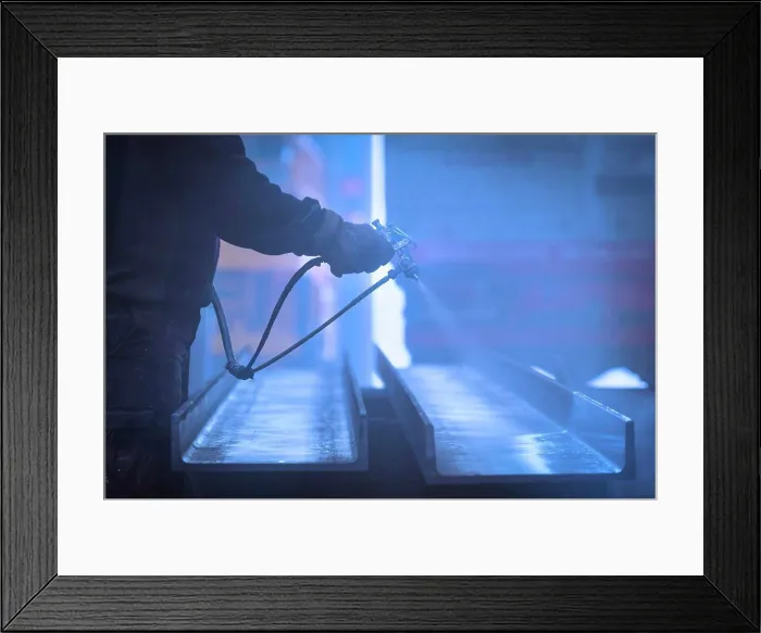Framed Print : Man with gloves painting and lacquering steel with compressor Framed Print : Man with gloves painting and lacquering steel with compressor