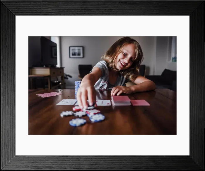 Framed Print : Girl playing cards at table, placing gambling chips Framed Print : Girl playing cards at table, placing gambling chips