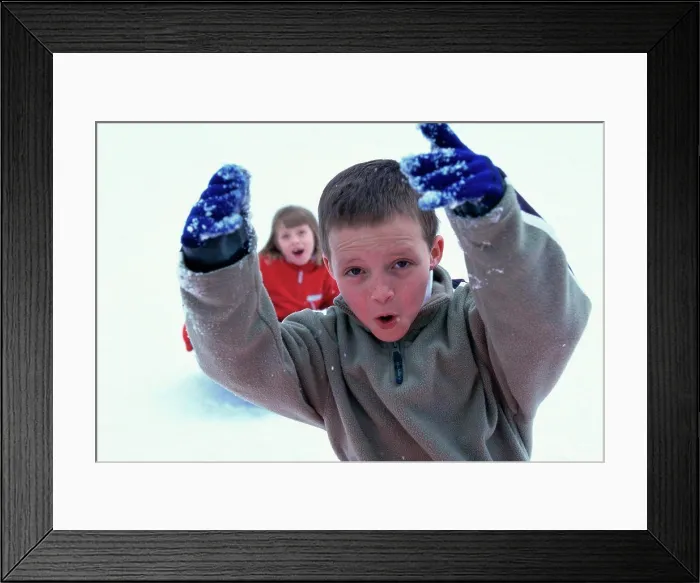 Framed Print : Close-up of a boy playing with snow Framed Print : Close-up of a boy playing with snow