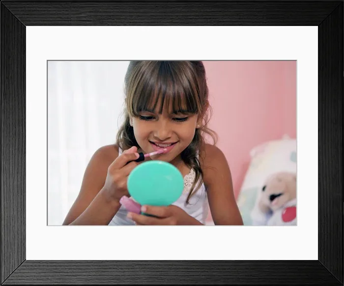 Framed Print : Close-up of a girl applying lipstick Framed Print : Close-up of a girl applying lipstick