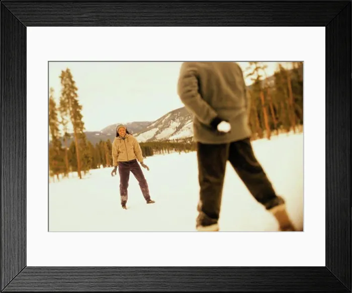 Framed Print : Young couple playing with snowballs in snow Framed Print : Young couple playing with snowballs in snow