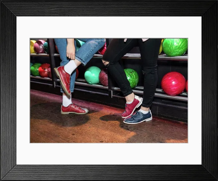 Framed Print : Low section of female friends wearing shoes standing by bowling rack Framed Print : Low section of female friends wearing shoes standing by bowling rack