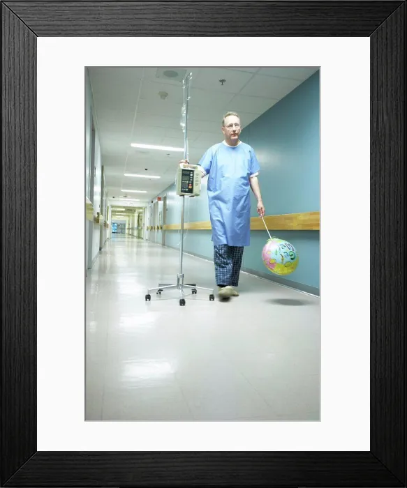 Framed Print : Low angle view of a male patient walking with an IV drip stand Framed Print : Low angle view of a male patient walking with an IV drip stand