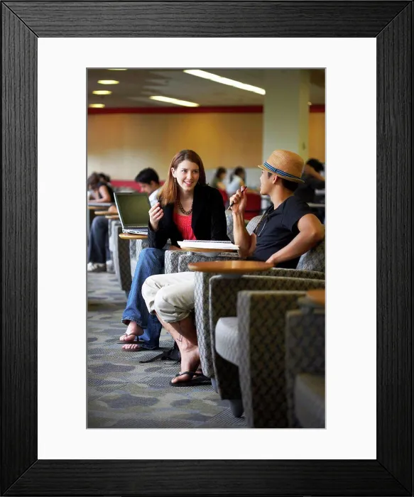 Framed Print : Side profile of two college students sitting in a lecture hall and talking to each other Framed Print : Side profile of two college students sitting in a lecture hall and talking to each other