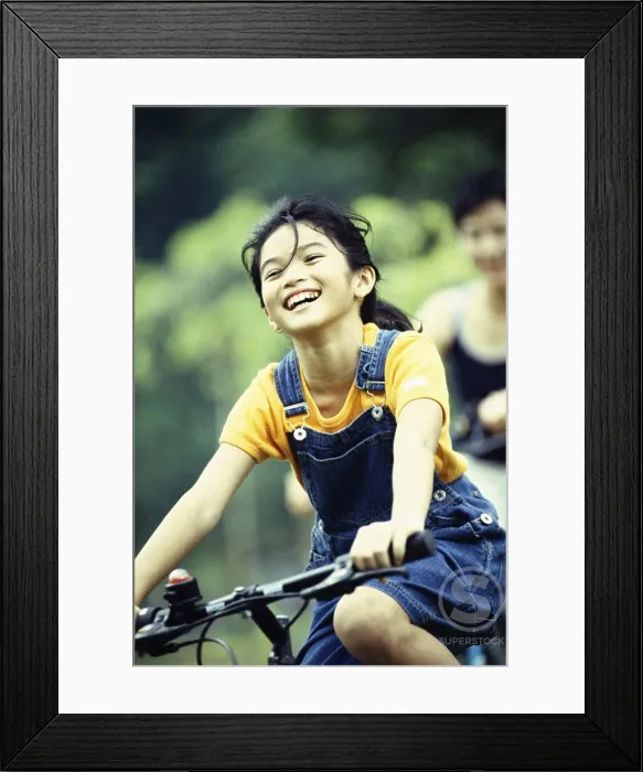 Framed Print : Girl cycling and smiling Framed Print : Girl cycling and smiling