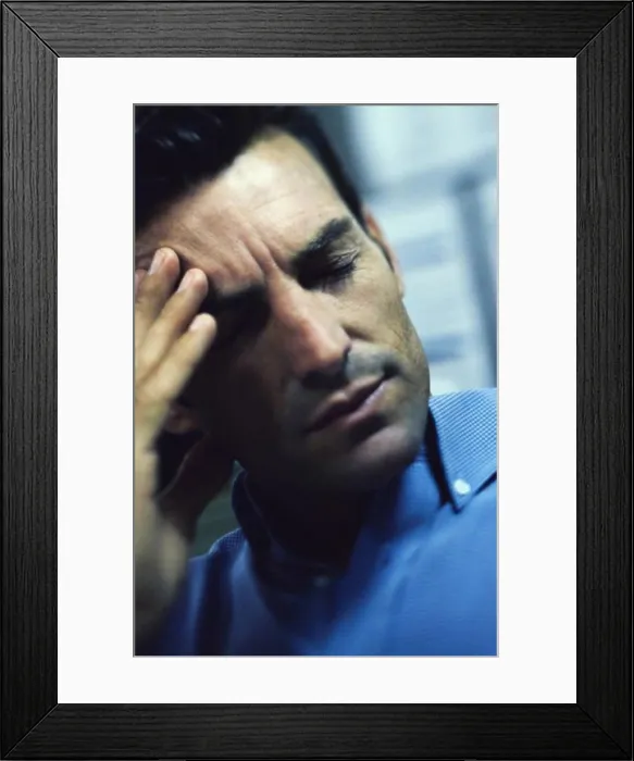Framed Print : Man holding his forehead in pain Framed Print : Man holding his forehead in pain
