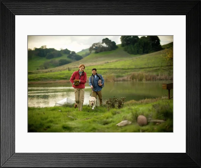 Framed Print : Mid-adult couple with their dog are carrying rocks beside a pond Framed Print : Mid-adult couple with their dog are carrying rocks beside a pond