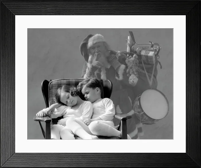 Framed Print : 1930S Santa Claus Finger To Lips Sack Of Christmas Toy Presents Over Shoulder Ghost Behind Boy And Girl Asleep In Chair Framed Print : 1930S Santa Claus Finger To Lips Sack Of Christmas Toy Presents Over Shoulder Ghost Behind Boy And Girl Asleep In Chair