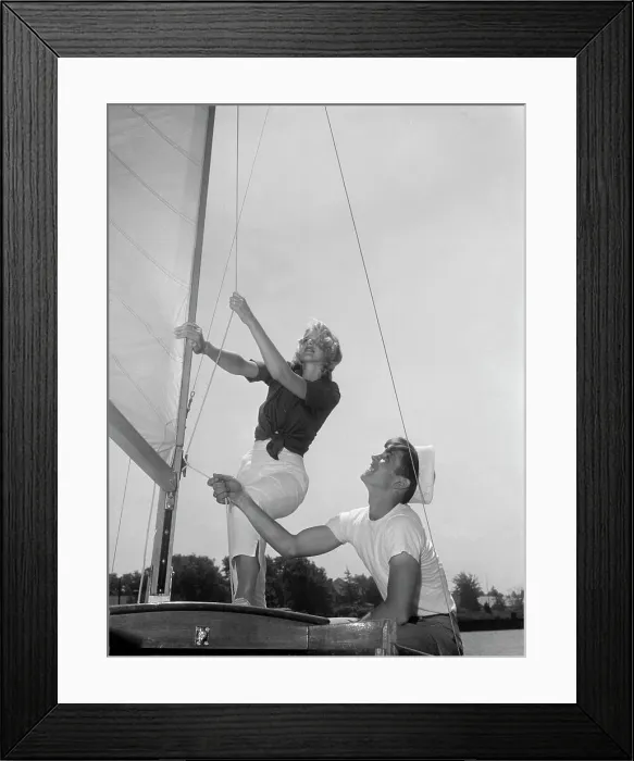 Framed Print : Couple on yacht deck adjusting sail