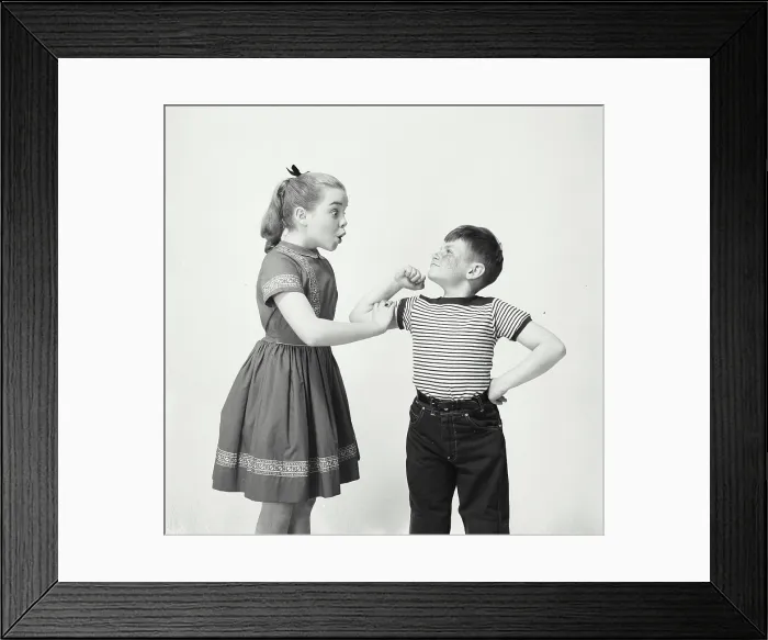 Framed Print : Side profile of a sister touching the bicep of her brother Framed Print : Side profile of a sister touching the bicep of her brother
