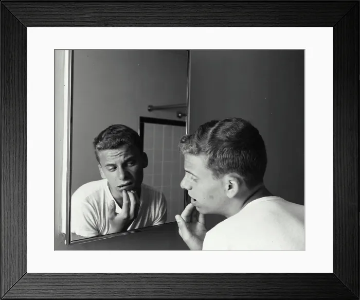 Framed Print : Rear view of a teenage boy looking at a mirror with his hand on his chin, 1960 Framed Print : Rear view of a teenage boy looking at a mirror with his hand on his chin, 1960
