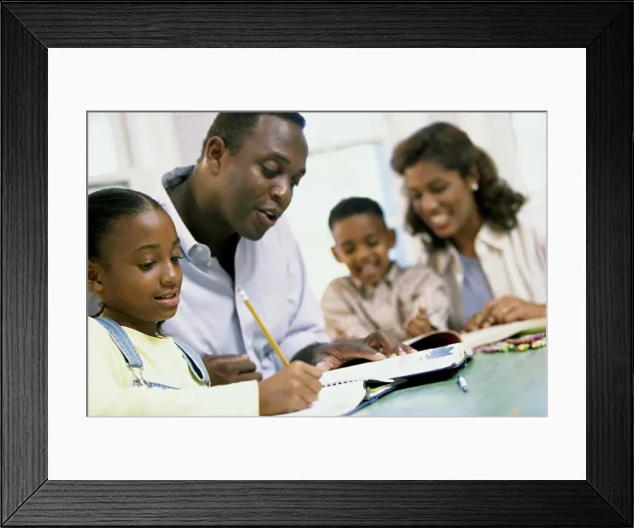 Framed Print : Parents helping their son and daughter with their homework