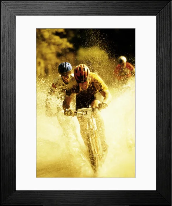 Framed Print : Young men riding bicycles through water Framed Print : Young men riding bicycles through water