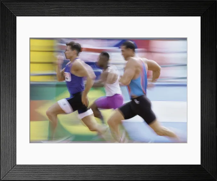 Framed Print : Side profile of three men running on a running track Framed Print : Side profile of three men running on a running track
