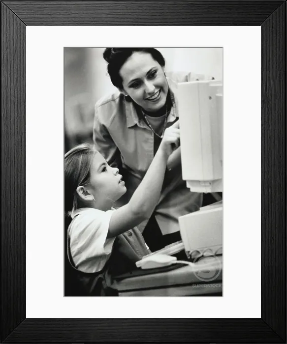 Framed Print : Female teacher and her student in front of a computer Framed Print : Female teacher and her student in front of a computer