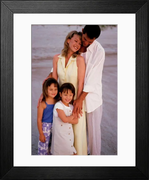 Framed Print : Parents and their two daughters standing on the beach Framed Print : Parents and their two daughters standing on the beach