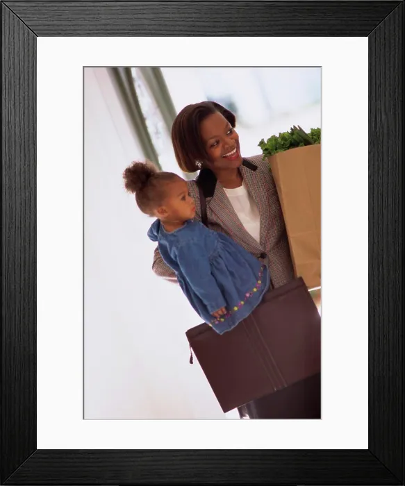 Framed Print : Mother carrying her daughter and holding shopping bags Framed Print : Mother carrying her daughter and holding shopping bags