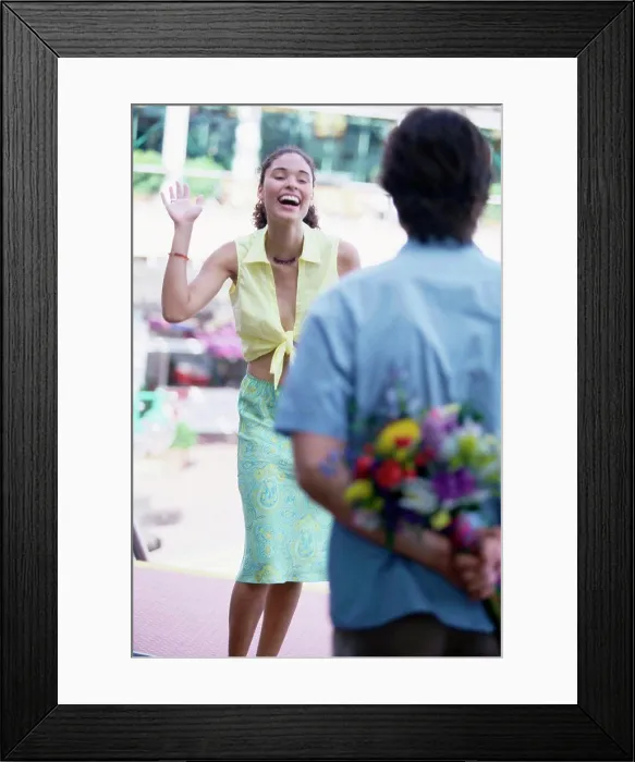 Framed Print : Rear view of a young man hiding a bouquet behind his back Framed Print : Rear view of a young man hiding a bouquet behind his back
