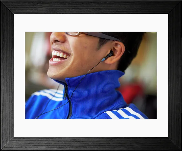 Framed Print : Close-up of a college student wearing headphones and listening to music