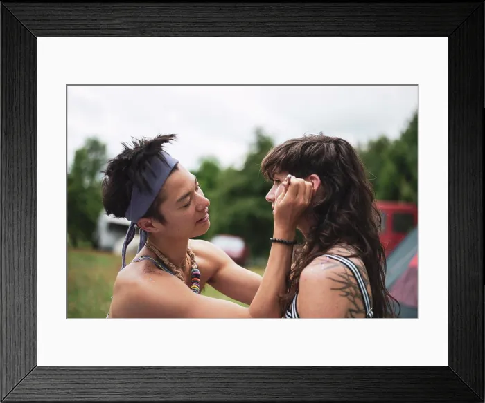 Framed Print : non-binary asian face paints woman with curly hair at festival camp Framed Print : non-binary asian face paints woman with curly hair at festival camp